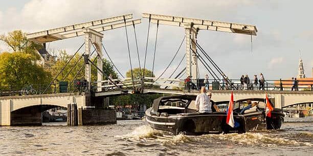 Two boats on their way to pass below the Magere Brug crossing the Amstel river.